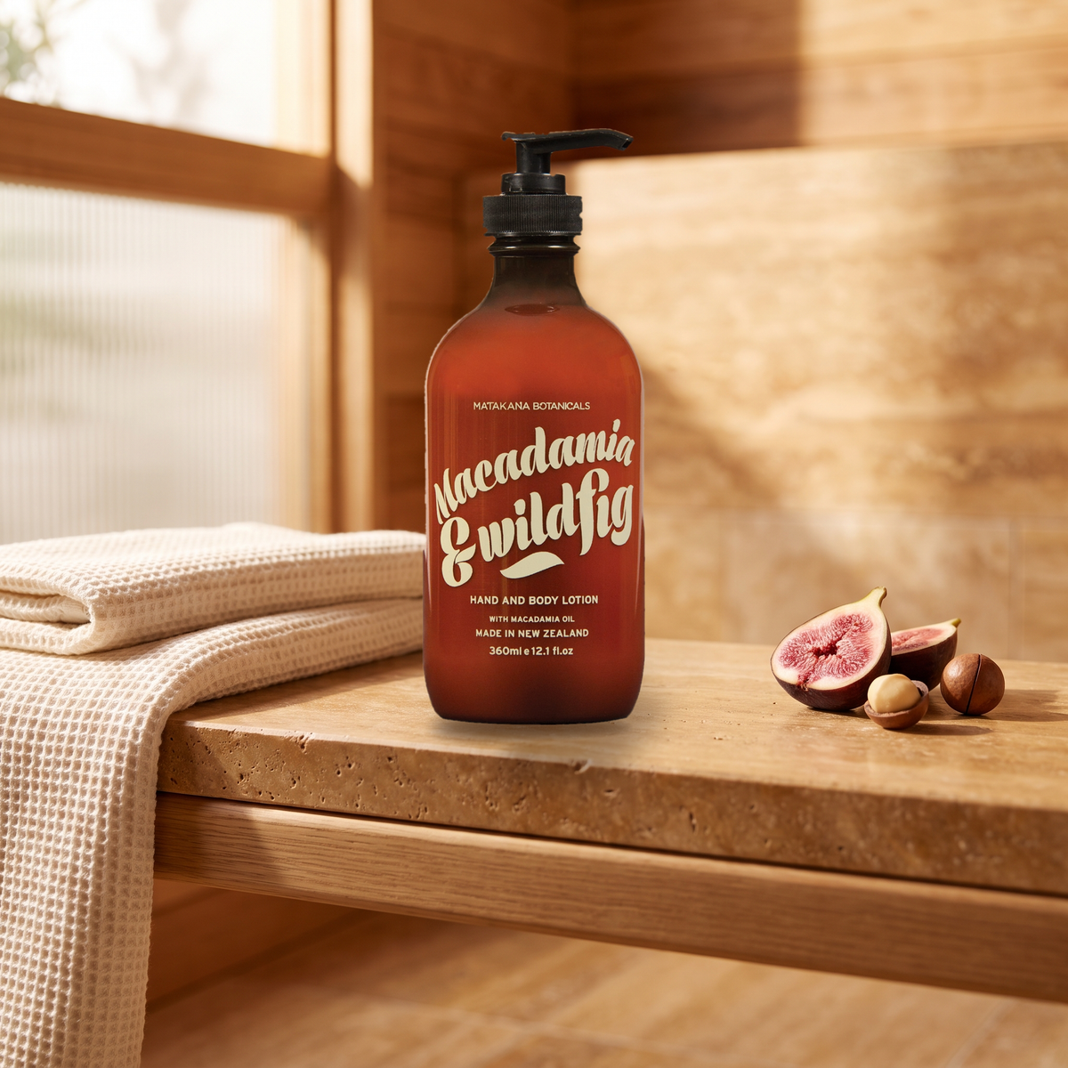 Macadamia & Wild Fig Hand & Body Lotion on a stone ledge with fig and macadamia