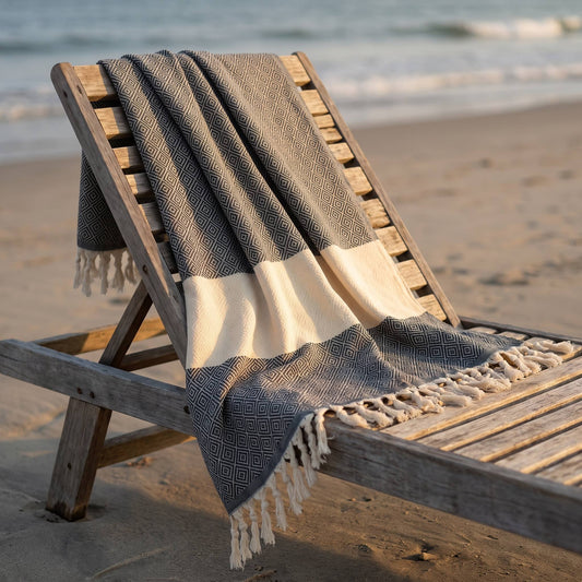 Turkish Towel in Black with Cream, draped over a wooden beach lounger